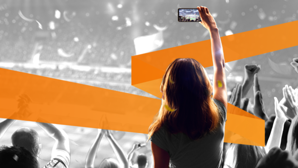 A woman at a concert at a large public venue capturing a video on her phone