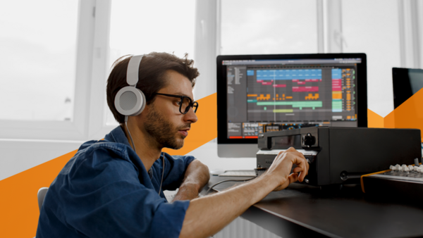 A professional audio technician working with various software and hardware devices