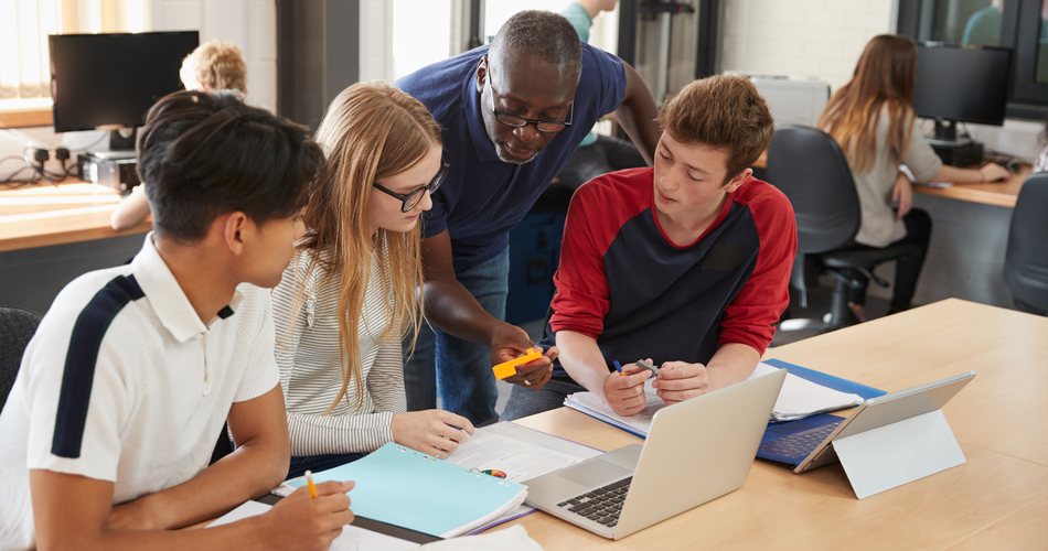 Higher education students working together in class with an instructor